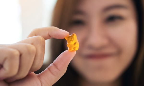 Žena drži gumeni vitamin kao primjer kako odabrati vitamine prema vlastitim potrebama